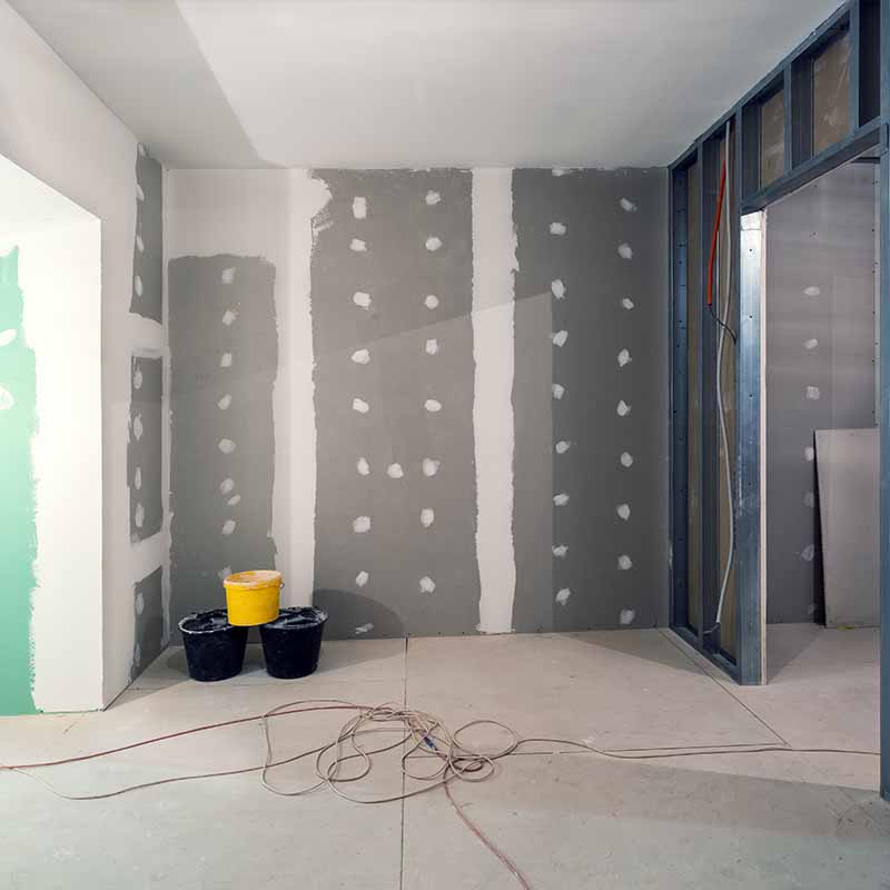 Chantier de rénovation à l'étape de la plâtrerie, hall avec mur en Placo plâtre et cloison légère